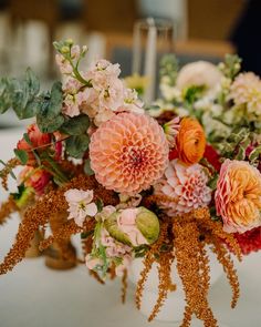 an arrangement of flowers on a table at a wedding