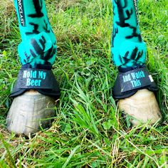 the legs and feet of a person wearing blue socks with black words on them, standing in grass