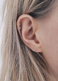 a close up of a person's ear with two piercings on the side