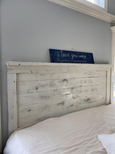 a white bed with a wooden head board