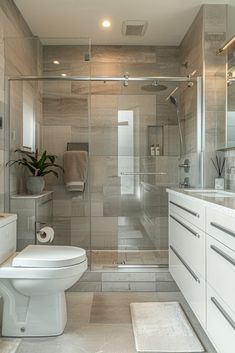 a white toilet sitting in a bathroom next to a walk - in shower and sink