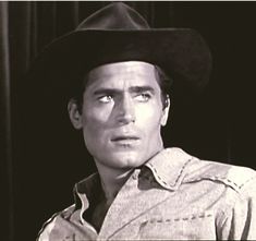 a man wearing a cowboy hat and looking at the camera with an intense look on his face