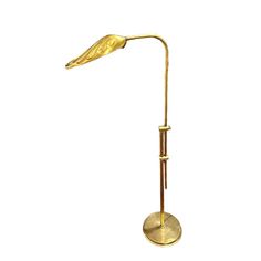 a gold colored floor lamp with a bird on it's arm and a metal base