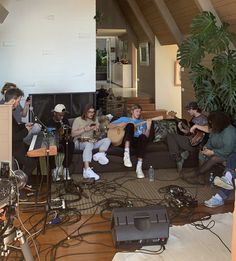 a group of people sitting on top of a couch in a living room next to each other