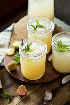 three glasses filled with lemonade sitting on top of a wooden table