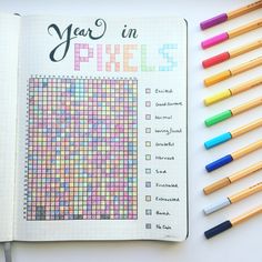 an open planner with colored pencils next to it and the words year in pixels