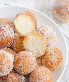 powdered sugar donuts on a white plate