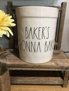 a white bucket with the words baker's donna bakery on it next to a yellow flower