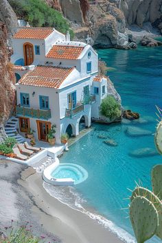 an aerial view of a white house on the beach with blue water and cactus trees