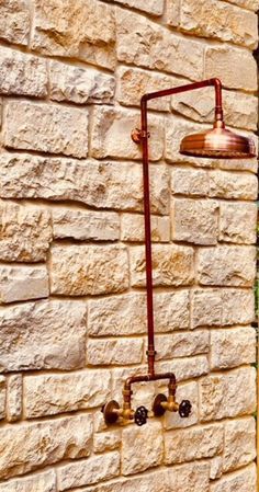 a brick wall with a lamp attached to it and two faucets on the side