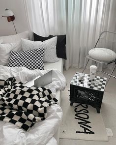 a black and white checkered blanket sitting on top of a bed next to a laptop computer