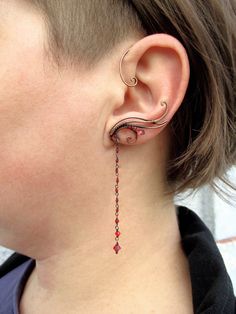 a close up of a person wearing some kind of ear piercing with beads on it