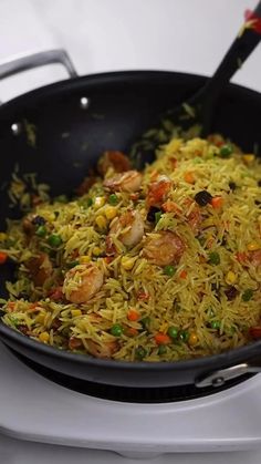 a pan filled with rice and vegetables on top of a stove