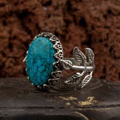 Turquoise Flower Silver Women Ring. Handmade in 925 sterling silver with turquoise stone. On the ring Oval Turquoise - Feroza stone settled. At sides, flower figure settled with micro detailed ornament. Dimensions of stone is 20 mm x 15 mm. Average weight of Turquoise Flower Silver Women Ring is 9 gr. (depends on your ring size). Back side is open and stone touches your skin. Classic and exclusive style. Stone Type: Turquoise - Feroza Stone Color: Blue Stone Dimensions: 20 mm x 15 mm Stone Shape Nature-inspired Turquoise Gemstone Jewelry, Nature-inspired Turquoise Sterling Silver Jewelry, Nickel-free Turquoise Jewelry, Nature-inspired Nickel Free Turquoise Jewelry, Nature-inspired Nickel-free Turquoise Jewelry, Feroza Ring, Feroza Stone, Silver Handmade Jewelry, Turquoise Flowers