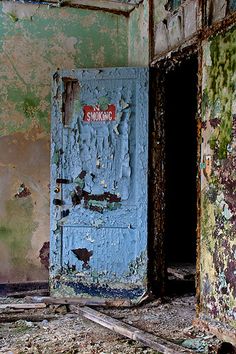 an old run down building with peeling paint on the walls and door that has been painted blue