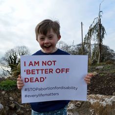 a young boy holding up a sign that says i am not better off dead