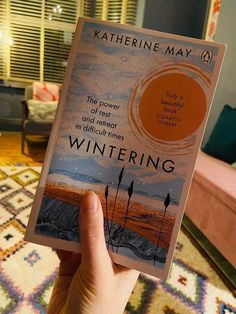 a person holding up a book in their hand with the title wintering written on it