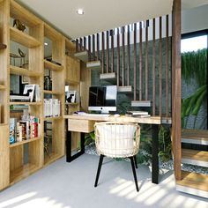 a computer desk sitting next to a wooden book shelf