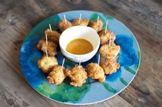 small appetizers with toothpicks and dipping sauce on a blue plate