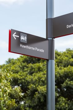 two street signs pointing in opposite directions on a pole with trees in the back ground