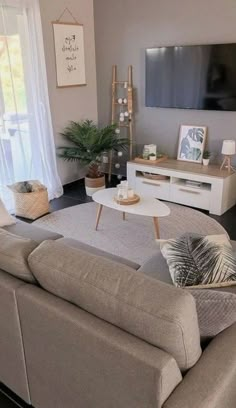 a living room filled with furniture and a flat screen tv mounted to the side of a wall