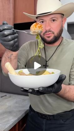 a man in a cowboy hat is holding a bowl with food on it while wearing gloves