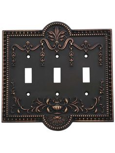 an ornate metal switch plate cover with two toggles and decorative designs on the front