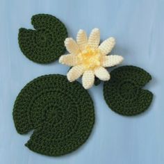 a crocheted flower and leaves on top of a blue background with text that reads water lily and leaves free crochet pattern