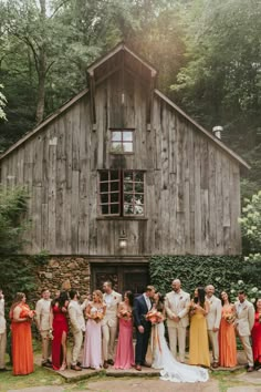 a large group of people standing in front of a building with a bride and groom