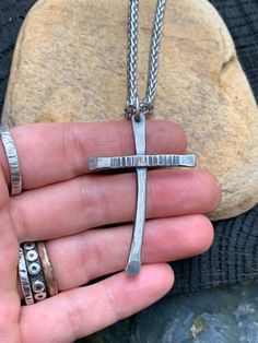 "This unique cross is hand crafted from solid, thick .925 Sterling silver and finished with a rustic hatched texture. I slightly oxidized the silver so that the texture would be more prominent. Cross comes with a high quality Stainless steel braided chain. Not your favorite metal or want a different size cross? Message me for a custom order! All jewelry from my studio is endowed with a lifetime craftsmanship guarantee & will arrive attractively packaged and ready for gifting or keeps. MEASUR Handmade Stainless Steel Cross Jewelry, Handmade Stainless Steel Cross Necklace, Handmade Stainless Steel Cross Pendant Necklace, Handmade Stainless Steel Cross Pendant Jewelry, Hand Cast Silver Cross Jewelry, Handmade Artisan Cross Pendant Necklace, Rustic Cross Jewelry For Gifts, Hand Forged Silver Cross Pendant Jewelry, Silver Hand Forged Cross Pendant Jewelry