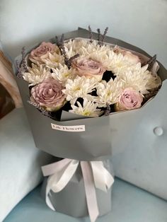 a bouquet of white and pink flowers in a gray box