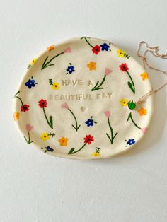 a ceramic plate with flowers on it that says have a beautiful day written on the side