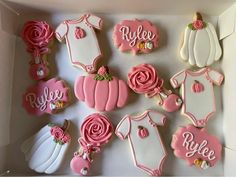 baby shower cookies in a box decorated with pink and white icing, including ones