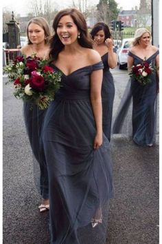 the bridesmaids are walking down the street with their bouquets