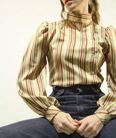 Stunning late 70s, early 80s American Made Blouse with Unique Design & Rare Colour Palette ~ there is a button up mock neckline that connects with the left side button down front ~ the shoulders are gathered and puffed with a shapely sleeve and button up cuff ~ Silky feel Polyester with stripes of two tone Red, Sage Green, Slate Blue, Muted Grey, Butter yellow and Camel Beige ~ Excellent Vintage Condition: minimal signs of wear if any! Label: Langtry. MADE IN U.S.A.  Best Fit: Small - Medium Sho Red Sage, Stripe Blouse, Butter Yellow, Mock Neckline, Slate Blue, Striped Blouse, American Made, Colour Palette, Sage Green