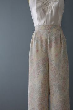 vintage dreamy pastel cottage-core wide high waisted wide gaucho sailor pants. high banded waist with elastic and button closure. Made by 10West Circa 1990s soft gauzy silky micro polyester exterior, white lining underpants. Fits like size medium: 30" waist 42" hips 39" length 15" rise 36" inseam In excellent condition! Spring Floral Print High Waist Wide Leg Pants, Elastic Waistband Bottoms For Spring Garden Party, Bottoms With Elastic Waistband For Spring Garden Party, Bottoms With Elastic Waistband For Garden Party In Spring, Feminine Floral Print Wide-leg Bottoms, Feminine Floral Print Wide Leg Bottoms, Vintage Wide Leg Floral Print Pants, Vintage Floral Print Summer Pants, Vintage Wide Leg Pants With Floral Print