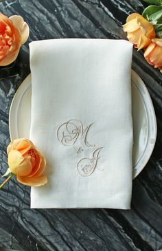 a white plate topped with a napkin and two orange flowers