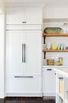 a kitchen with open shelving and white cabinets