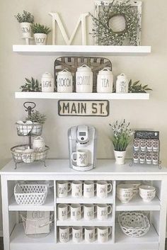 a white shelf with coffee cups and mugs on it in front of a sign that says main st