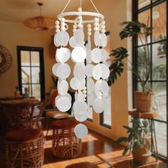 a chandelier hanging from the ceiling in a room with wooden tables and chairs