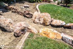 a garden with rocks and grass around it