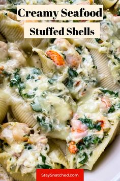 creamy seafood stuffed shells with spinach and carrots in a cream sauce on top