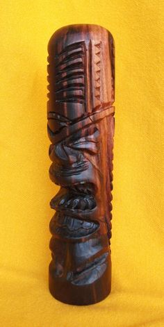 a carved wooden object sitting on top of a yellow cloth