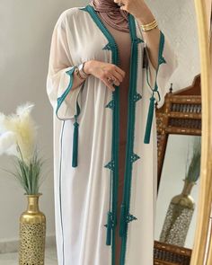 Are you looking for an elegant and traditional outfit for the summer? The Moroccan summer jellaba is perfect with its lightweight fabric and fine embroidery. If you like sets, the embroidered 2-piece djellaba is ideal with its intricate details. For a modest yet chic look, go for the hooded caftan. Each Moroccan dress you wear tells a part of the cultural history of the Arab world. For a special occasion like an Islamic wedding, nothing beats the Nikah dress, richly adorned. The hooded Moroccan Summer Kaftan With Dabka Work, Elegant Summer Kaftan With Dabka Work, Green Embroidered Kaftan For Eid, Summer Wedding Long Abaya, Traditional Maxi Length Abaya For Summer, Traditional Summer Maxi Length Abaya, Traditional Maxi Length Summer Abaya, Traditional Maxi-length Summer Abaya, Traditional Floor-length Abaya For Summer