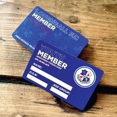 two credit cards sitting on top of a wooden table