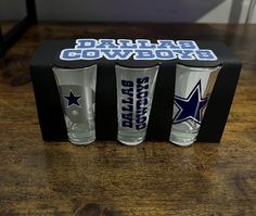 three shot glasses in a box with the cowboys logo on it and two other shots