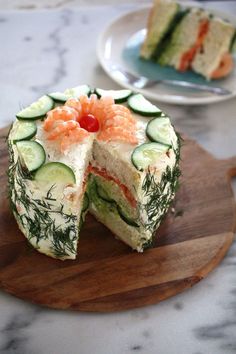 a cucumber and salmon cake on a cutting board with one slice cut out