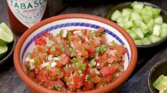 a bowl filled with chopped up tomatoes and green onions next to other bowls of diced celery