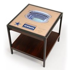 a wooden table with a glass top that has an image of cowboys stadium on it