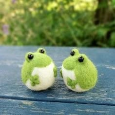 two small stuffed animals sitting on top of a wooden table next to an arrow pointing in the opposite direction